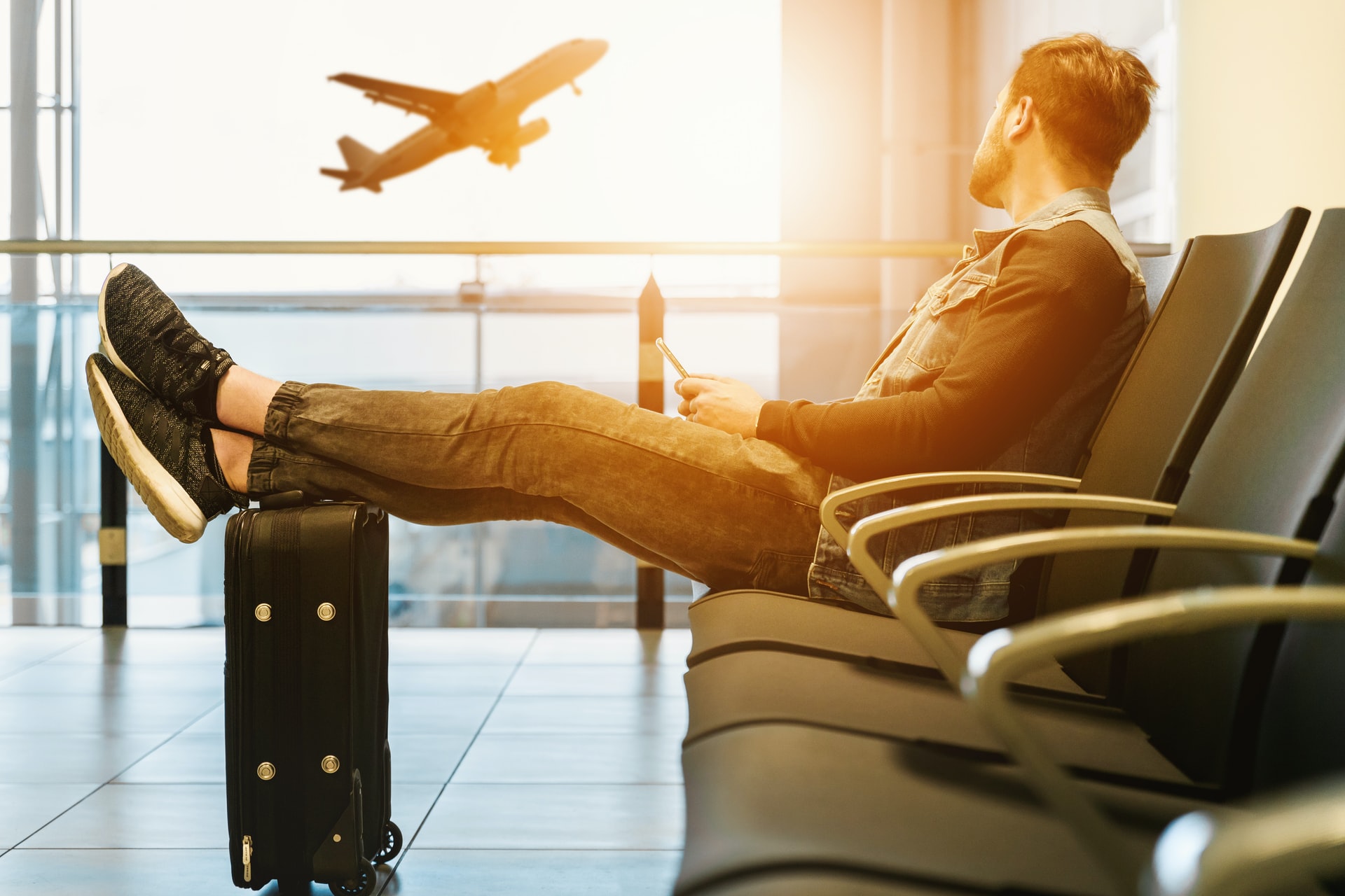 A person sitting on an AirPort to travel along with his luggage