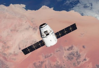 A picture of SpaceX's Dragon spacecraft with solar arrays deployed carrying cargo to the International Space Station (ISS) for NASA.