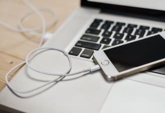 A photo of iPhone plugged in to a MacBook