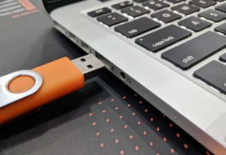 A photo of a USB about to plug in the laptop