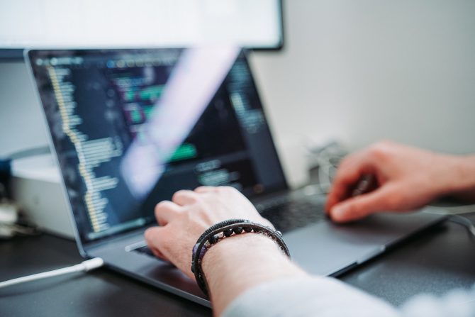 A Person Coding On A Laptop