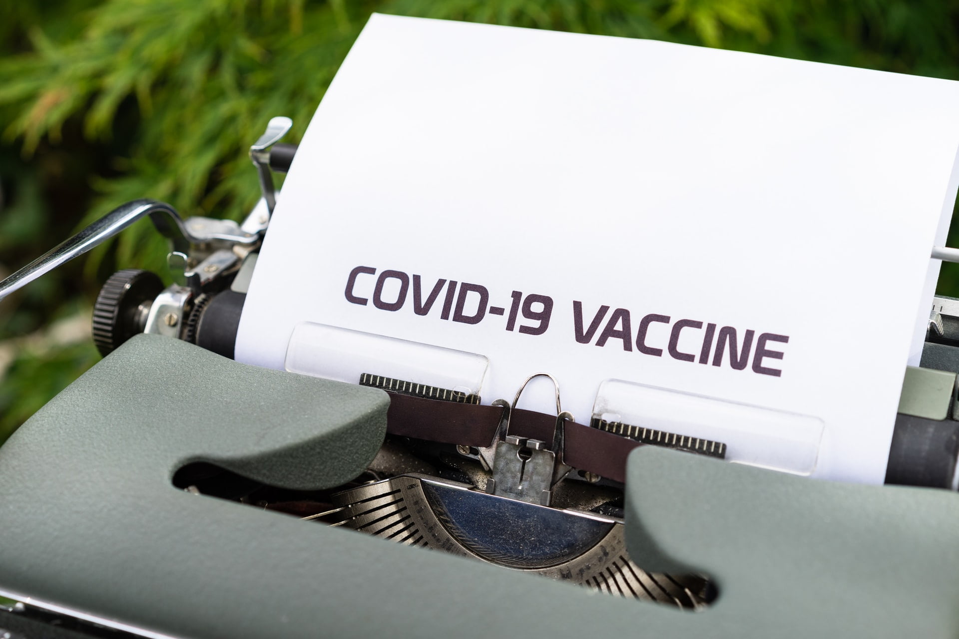 An image of type writer writing COVID-19 Vaccine