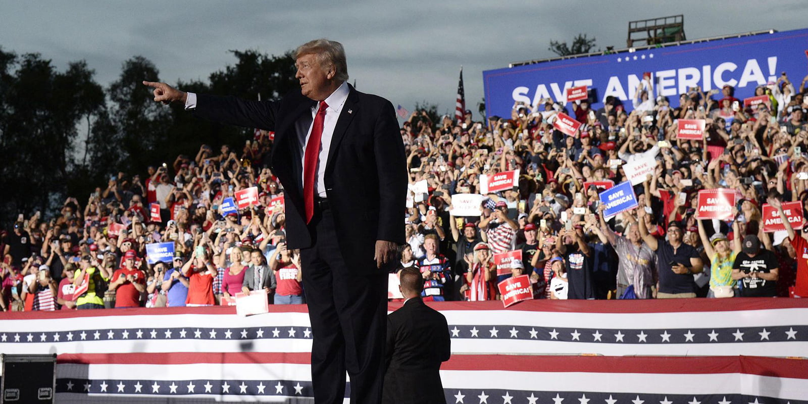 Trump waving hands while seeing his supporters